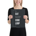 Product mockup- Person holding a black poster with 'EAT SLEEP CODE LOOP' text.